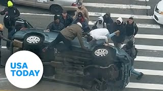 Good Samaritans New York City rush to help stuck driver flipped car  USA TODAY [upl. by Godrich]